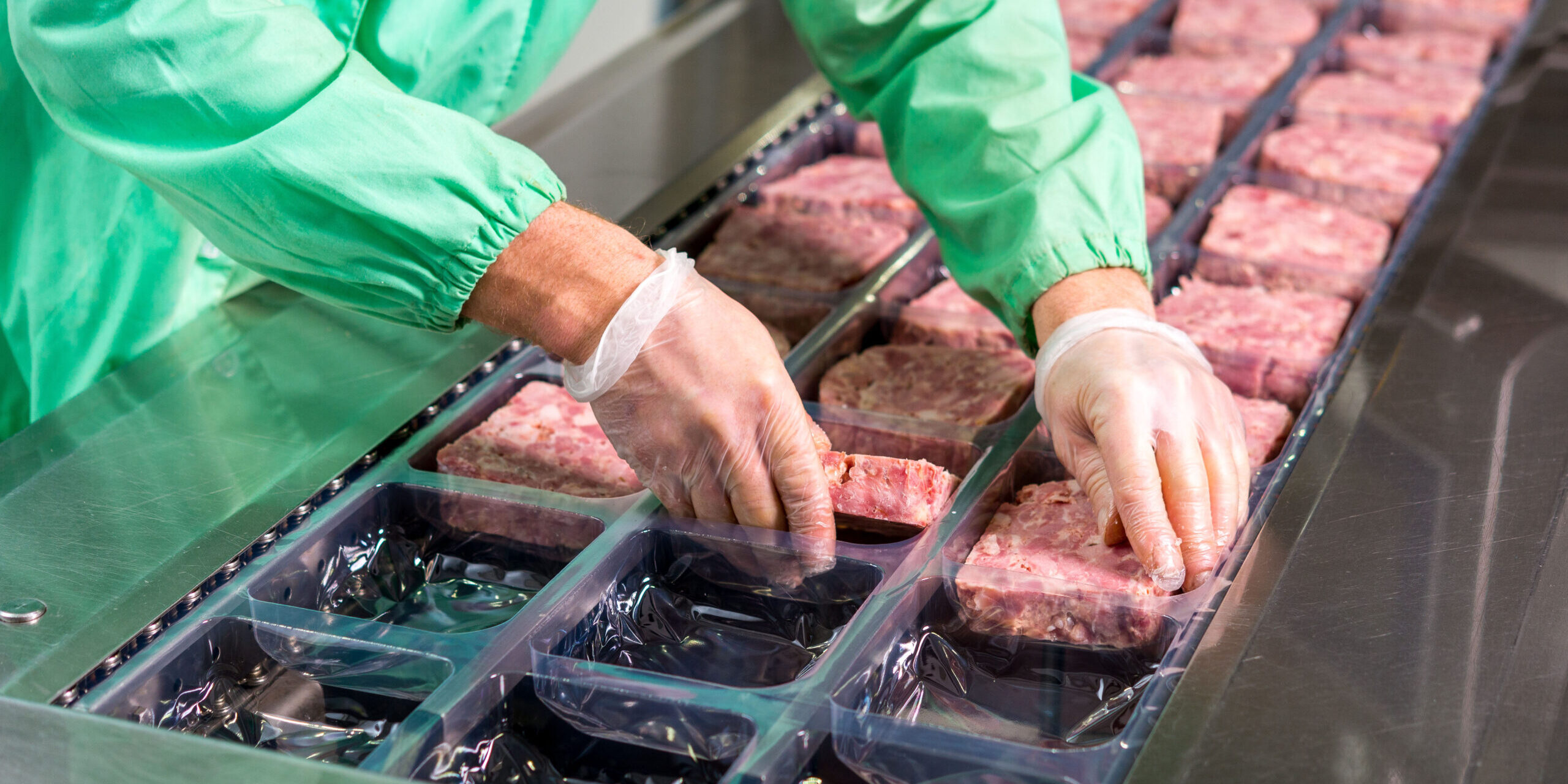 Several chunks of raw meat being processed packaged and shipped